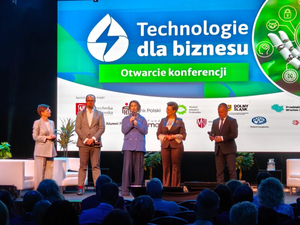 Otwarcie Technologii dla Biznesu 2026 - pięć osób stoi na scenie, w tle logotyp wydarzenia